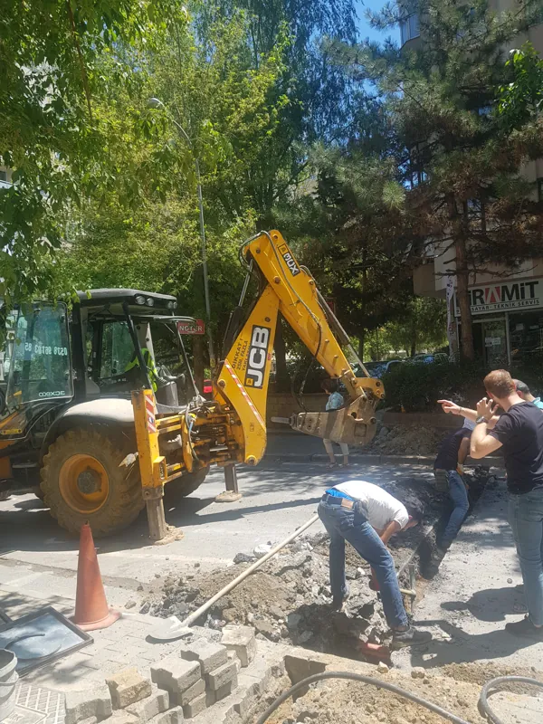 Yol kenarında kazıcı yükleyici ve saha çalışması