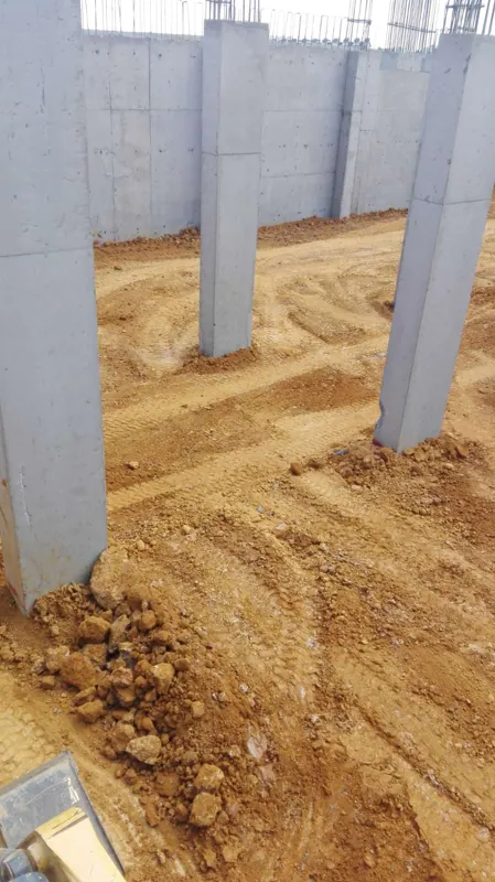 Betonarme yapı içinde iş makinesi izleri bulunan toprak zemin